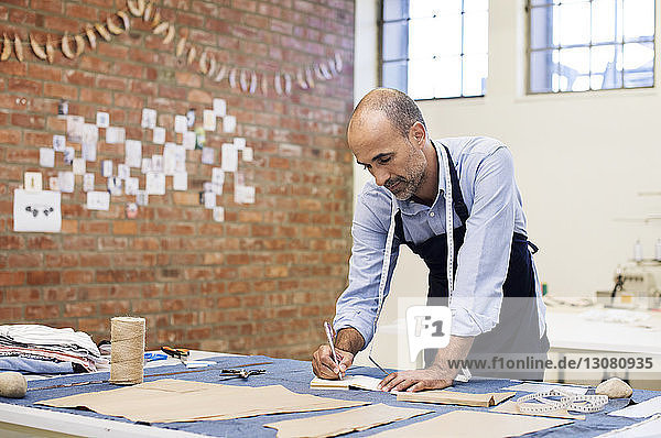 Male fashion designer working at table in workshop