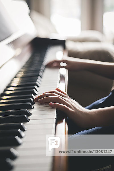 Ausgeschnittenes Bild eines Jungen  der zu Hause Klavier spielt