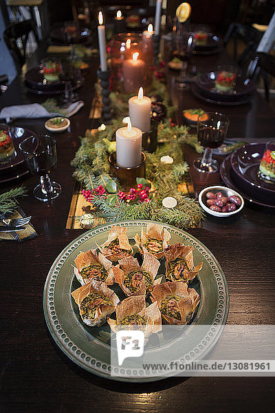 Schrägaufnahme von Lebensmitteln,  die an Weihnachten auf einem geschmückten Tisch serviert werden