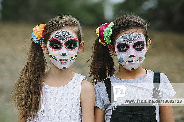 Portrait of sisters with face paint during Halloween