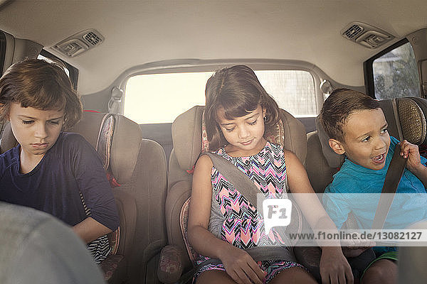 Frontansicht der im Auto sitzenden Geschwister