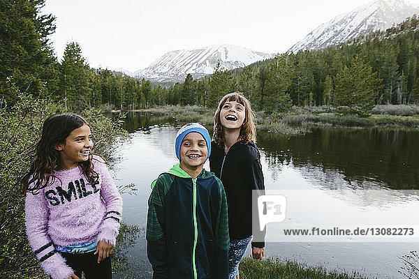 Happy siblings standing at lakeshore in Inyo National Forest