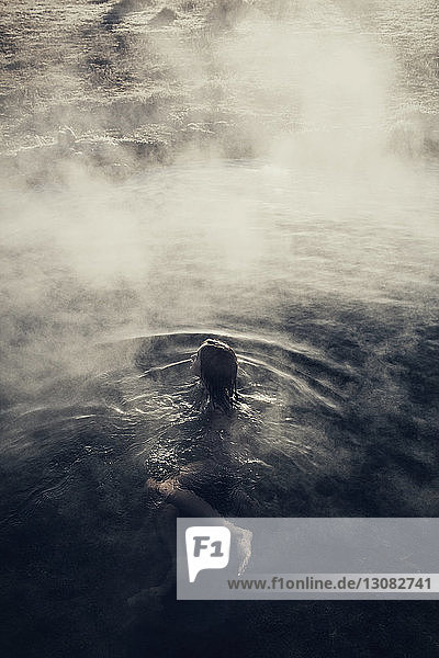 Hochwinkelaufnahme einer im Wasser sitzenden Frau an den Mammoth Lake Hot Springs