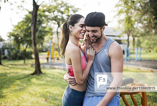 Glückliches Paar umarmt und unterhält sich im Park