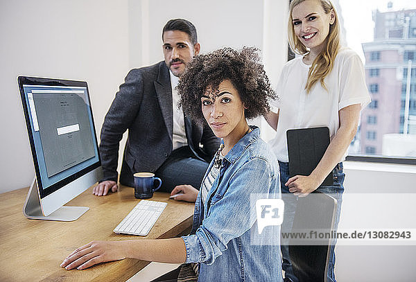 Porträt von selbstbewussten Geschäftsleuten  die den Computer am Schreibtisch im Büro benutzen