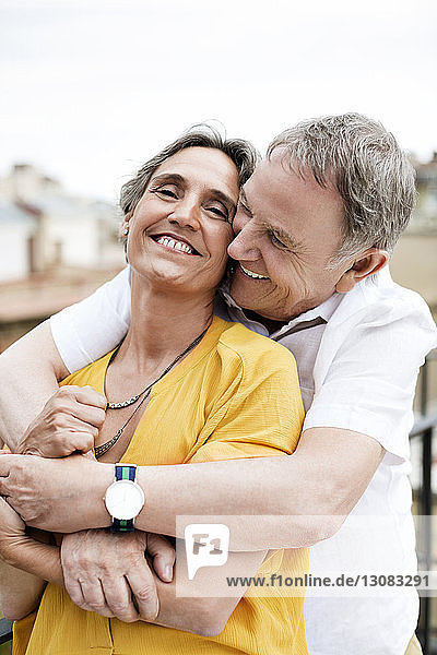 Liebender älterer Mann umarmt Frau auf Terrasse
