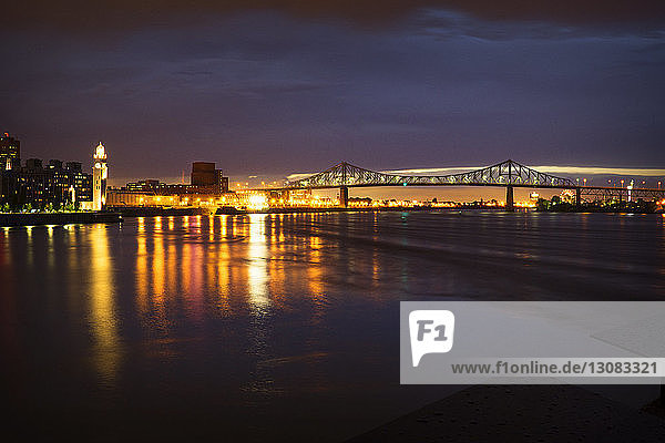 Beleuchtete Brücke über den Fluss bei Nacht