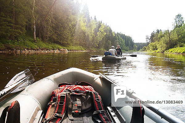 Couple traveling on inflatable boat in river during summer