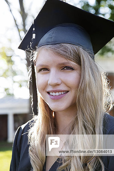 Close-up of cheerful woman in graduation gown