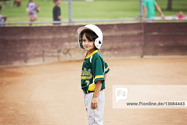 Lächelnder Junge auf dem Spielfeld stehend