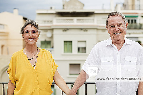 Portrait of happy senior couple standing on terrace
