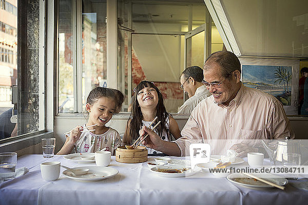 Happy family having food while sitting in restaurant