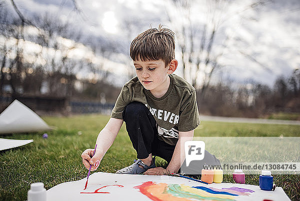 Junge malt auf Papier im Park