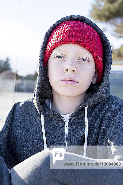 Porträt eines selbstbewussten Jungen mit Strickmütze und Kapuzenhemd