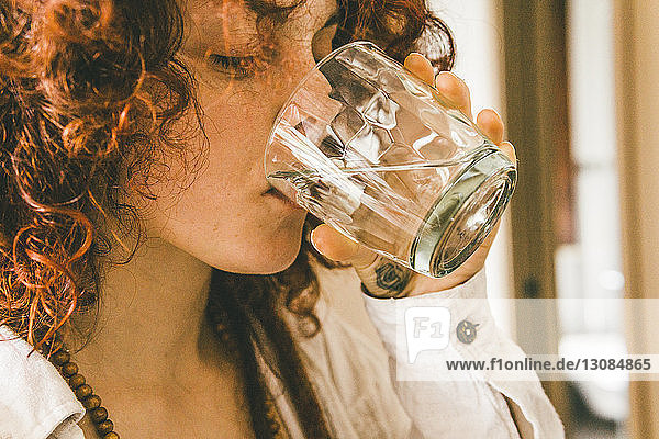 Nahaufnahme einer Frau  die zu Hause Wasser trinkt