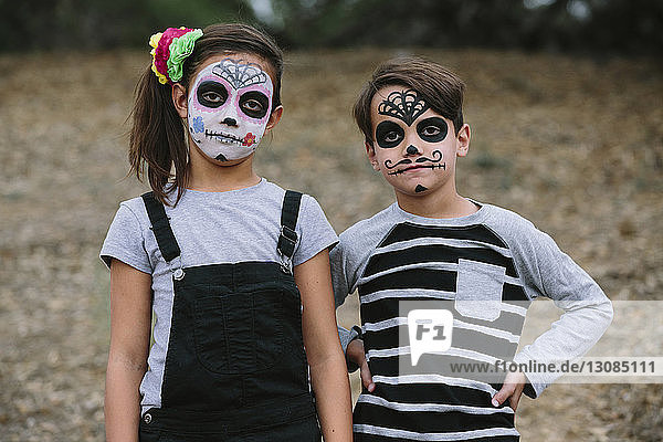 Portrait of siblings with face paint during Halloween