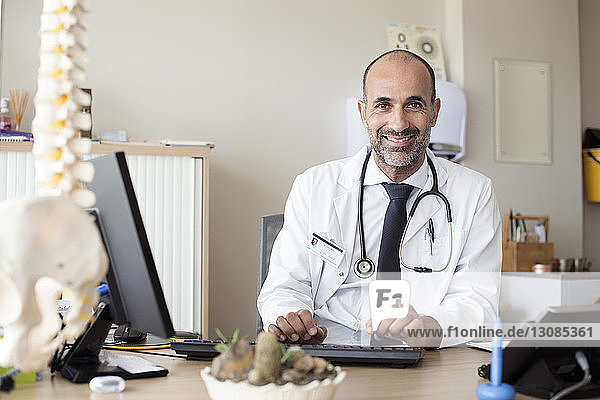 Porträt eines Arztes  der im Krankenhaus am Tisch arbeitet