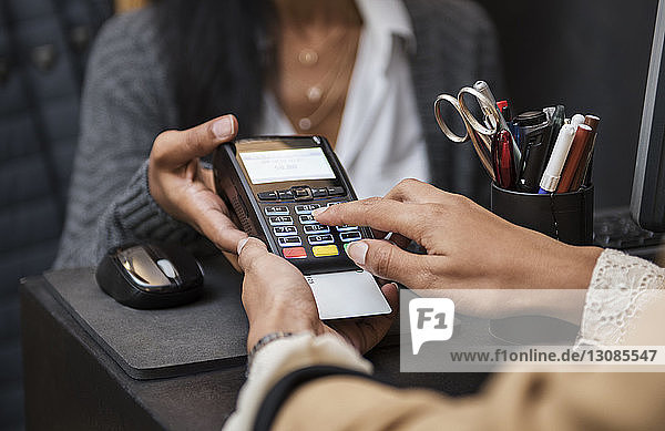 Frau macht Kreditkartenzahlung an der Kasse im Laden