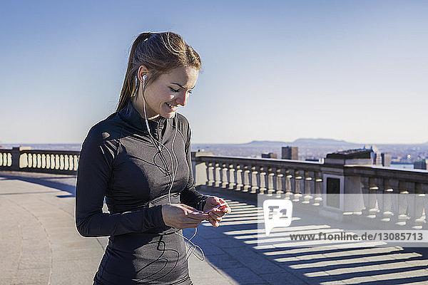 Young woman with headphones using smartphone