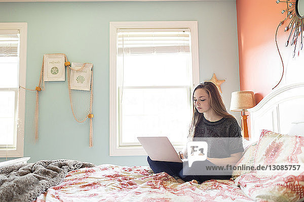 Frau benutzt Laptop-Computer zu Hause am Bett