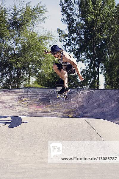 Junger Mann macht Skateboardtrick auf Rampe