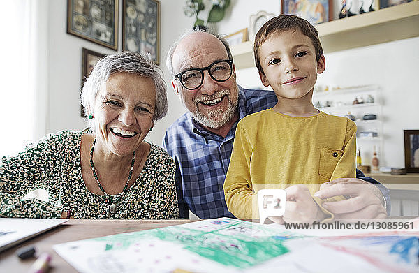 Porträt von glücklichen Großeltern mit Enkel zu Hause
