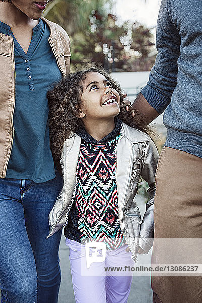 Daughter walking with parents on footpath