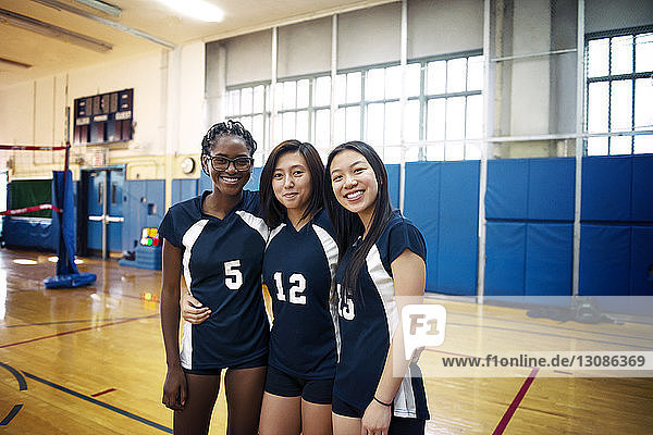 Glückliche Teenager-Mädchen stehen auf dem Volleyballfeld