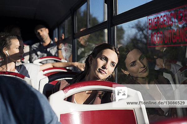 Touristen  die während einer Busreise durch ein Fenster schauen