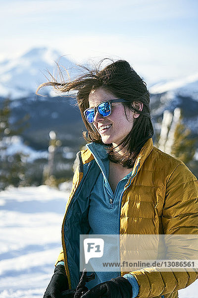 Smiling woman standing on field during winter