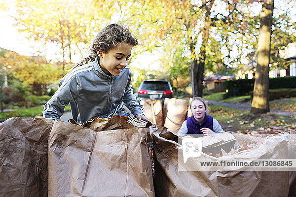 Freunde sammeln Herbstblätter auf der Straße