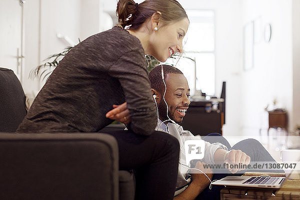 Happy illustrators using laptop in creative office