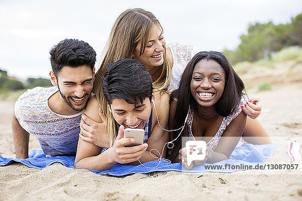 Cheerful woman lying on friends at beach