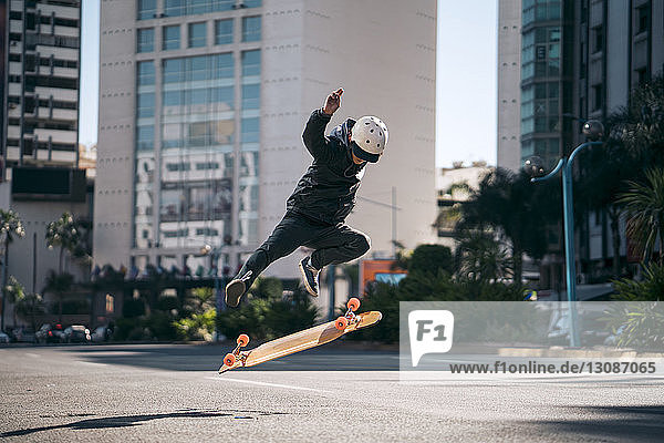 Mann führt Stunt beim Skateboardfahren auf der Straße in der Stadt aus