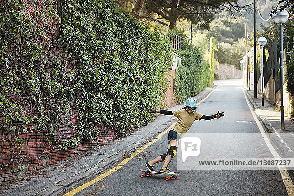 Woman skateboarding on road in city