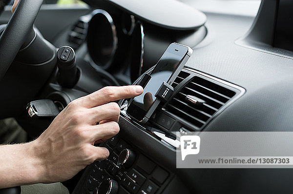 Männliche Hand benutzt GPS am Smartphone im Auto