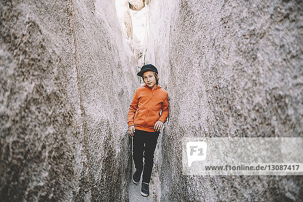 Porträt eines Jungen  der bei Felsformationen im Joshua-Tree-Nationalpark steht