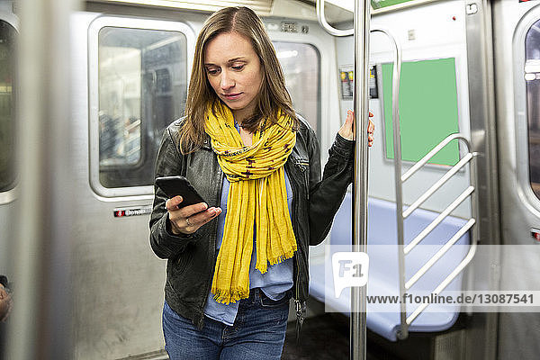 Frau benutzt Smartphone während einer Zugfahrt