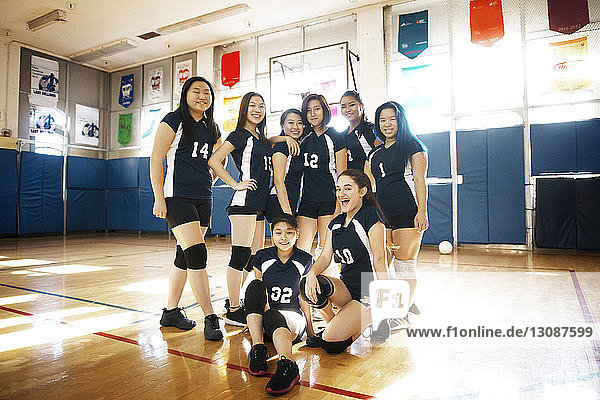 Portrait of happy female volleyball team at court