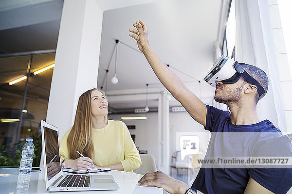 Kollegen untersuchen Virtual-Reality-Simulator im Büro