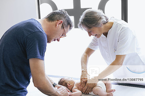Mann hält kleinen Jungen während der Untersuchung in medizinischer Klinik