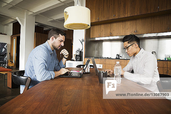 Geschäftspartner mit Laptop-Computer auf dem Tisch im Kreativbüro