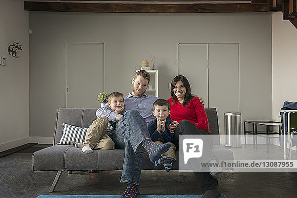 Portrait of happy family sitting on sofa at home