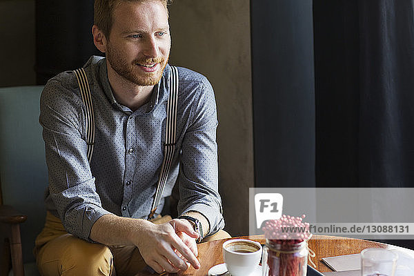 Smiling businessman sitting at table in hotel lobby