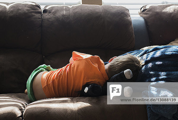 Rückansicht eines Jungen  der sich zu Hause auf dem Sofa entspannt