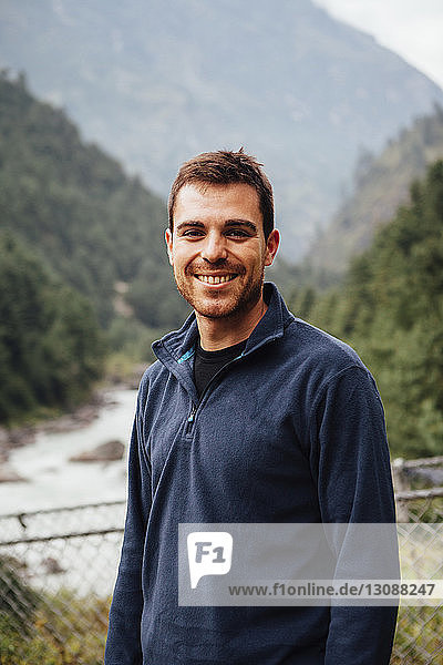 Porträt eines lächelnden Mannes an den Bergen im Sagarmatha-Nationalpark