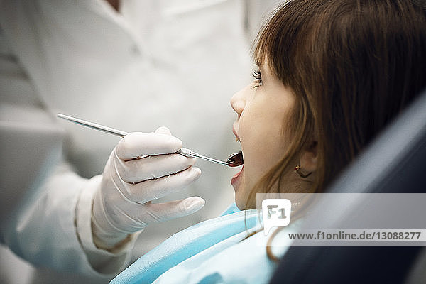 Mittelteil eines Zahnarztes untersucht Mädchen in der Klinik