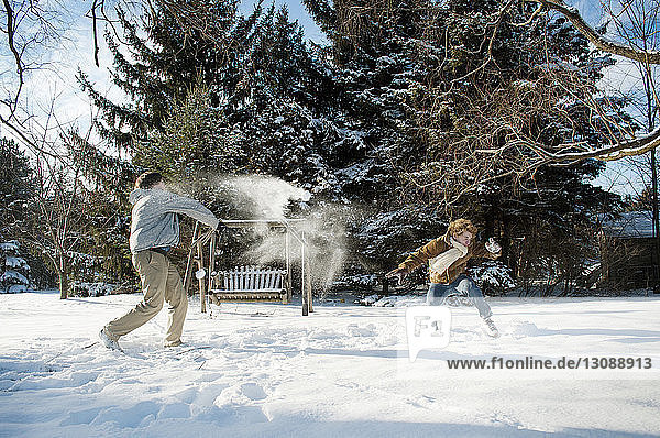 Glückliche Brüder spielen im Hinterhof mit Schnee