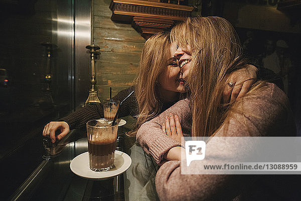 Glückliches lesbisches Paar sitzt im Cafe