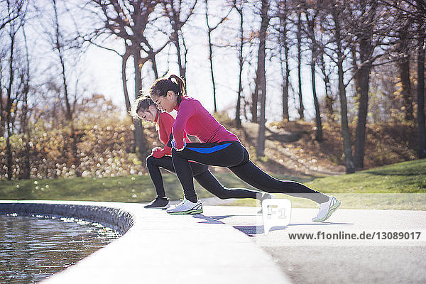 Two women stretching in park